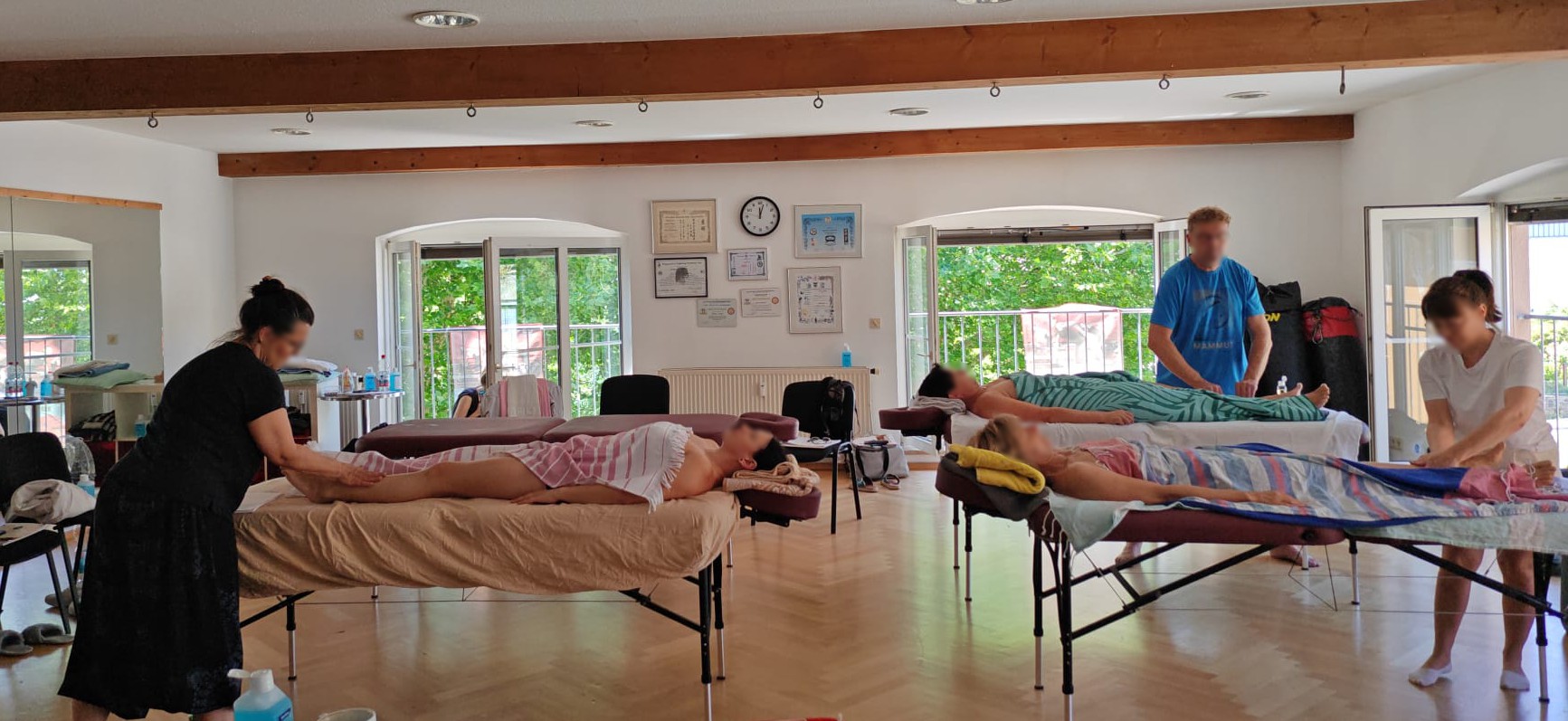 Kursraum Massageschule Baumann – Teilnehmer üben Wellnessmassage in kleiner Gruppe