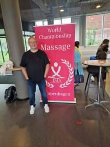 Peter Baumann vor dem World Championship Massage Banner in Kopenhagen 2022